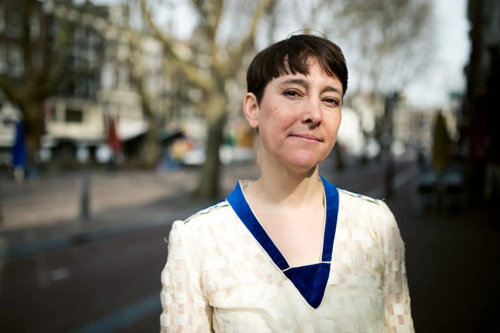 Jennifer Lyon Bell dans une rue bordée d’arbres